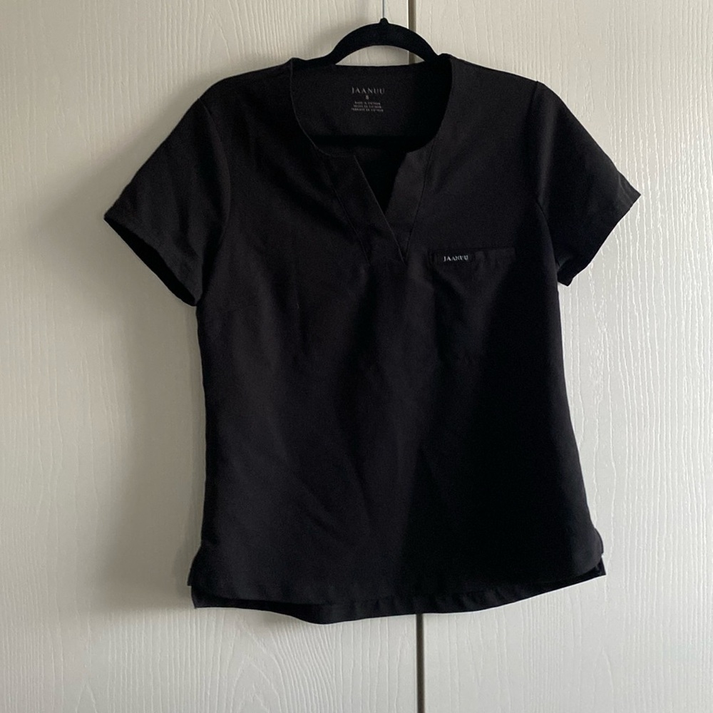 This is a black jaanuu one pocket scrub top. Never worn